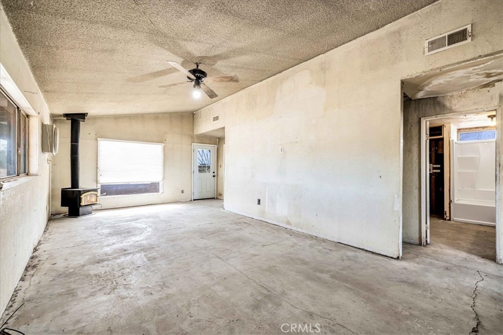 59724 Stearman Road Landers, CA 92285 - Photo 10 of 38 an empty room with windows and fan