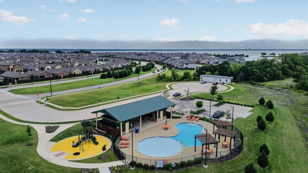 2428 Rosharon Drive Forney, TX 75126 - Photo 31 of 40 Expansive residential community featuring a resort-style amenity center with a custom saltwater pool, splash pad with water features, and dedicated play structure set within manicured landscaping