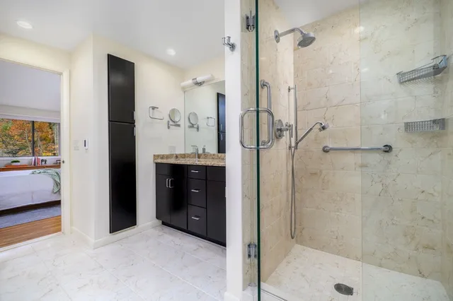 a bathroom with a glass door shower a sink and a mirror