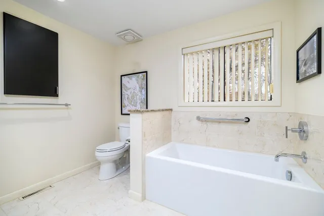 a white bath tub sitting next to a white toilet