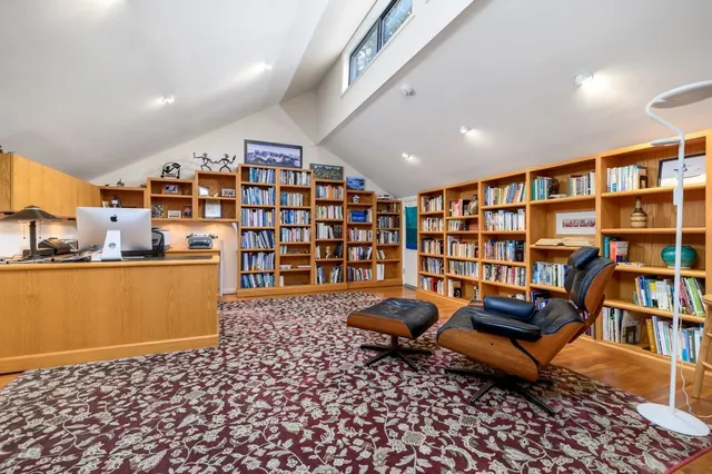 a reading room with furniture book shelf and a rug
