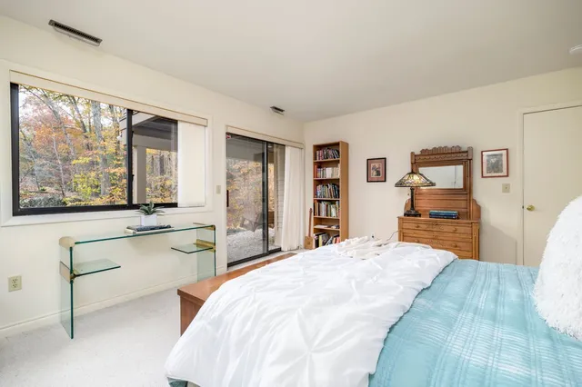 a bedroom with a bed and a large window