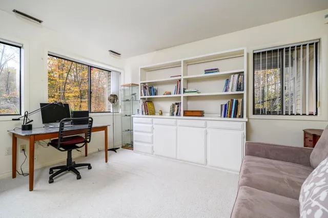 a view of a livingroom with workspace and a window