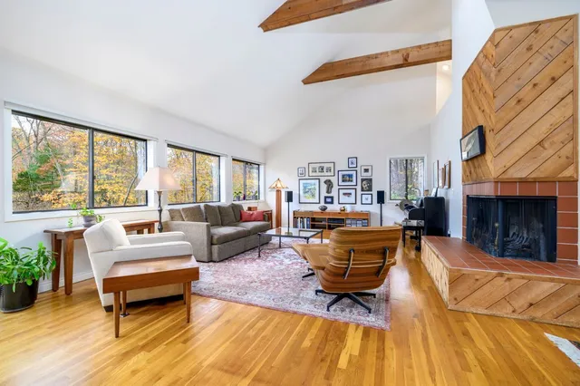 a living room with furniture a fireplace and a large window