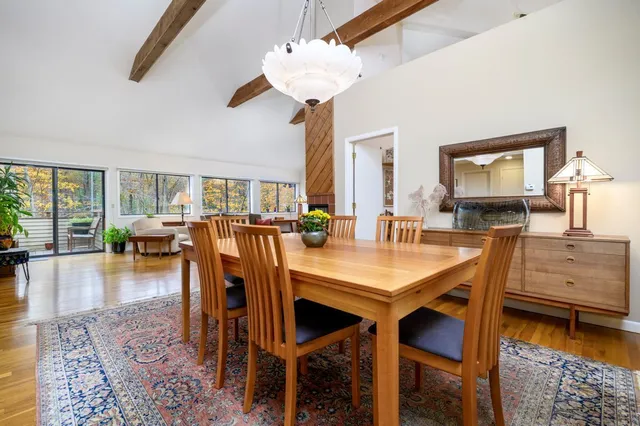 a dining room with wooden floor and chandelier