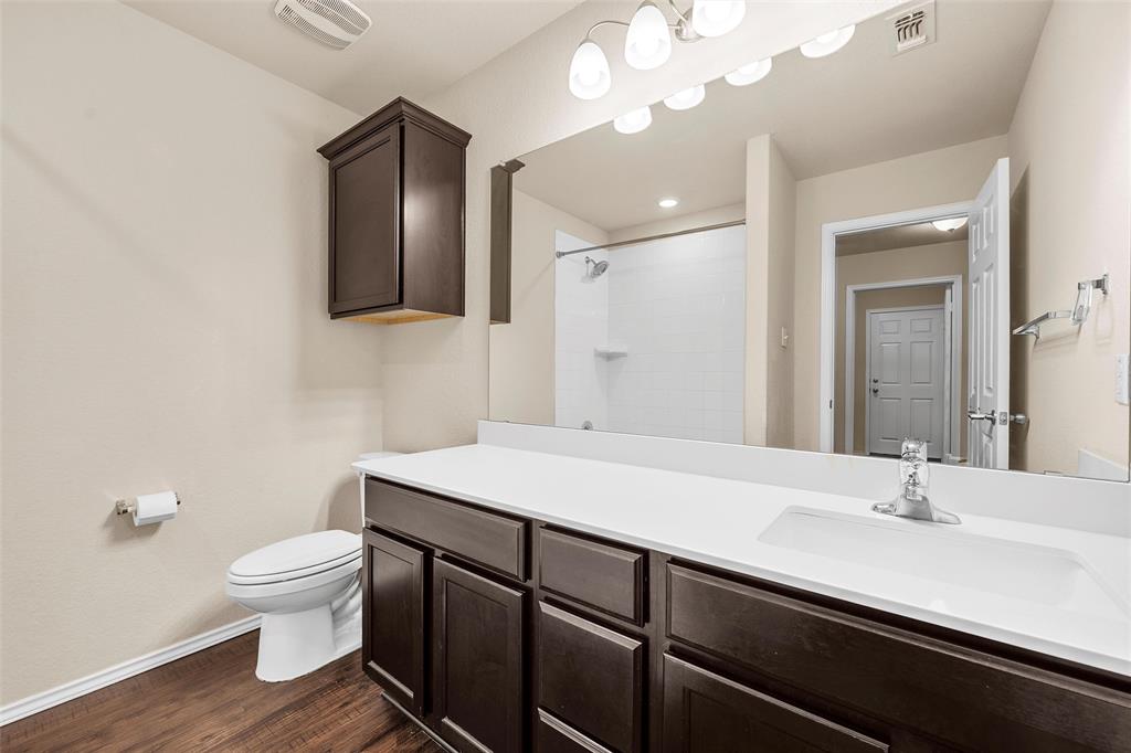 3217 Beutel Road Lorena, TX 76655 - Photo 22 of 40 Bathroom with vanity, tiled shower, and wood finished floors