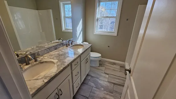 a bathroom with a granite countertop sink and a mirror