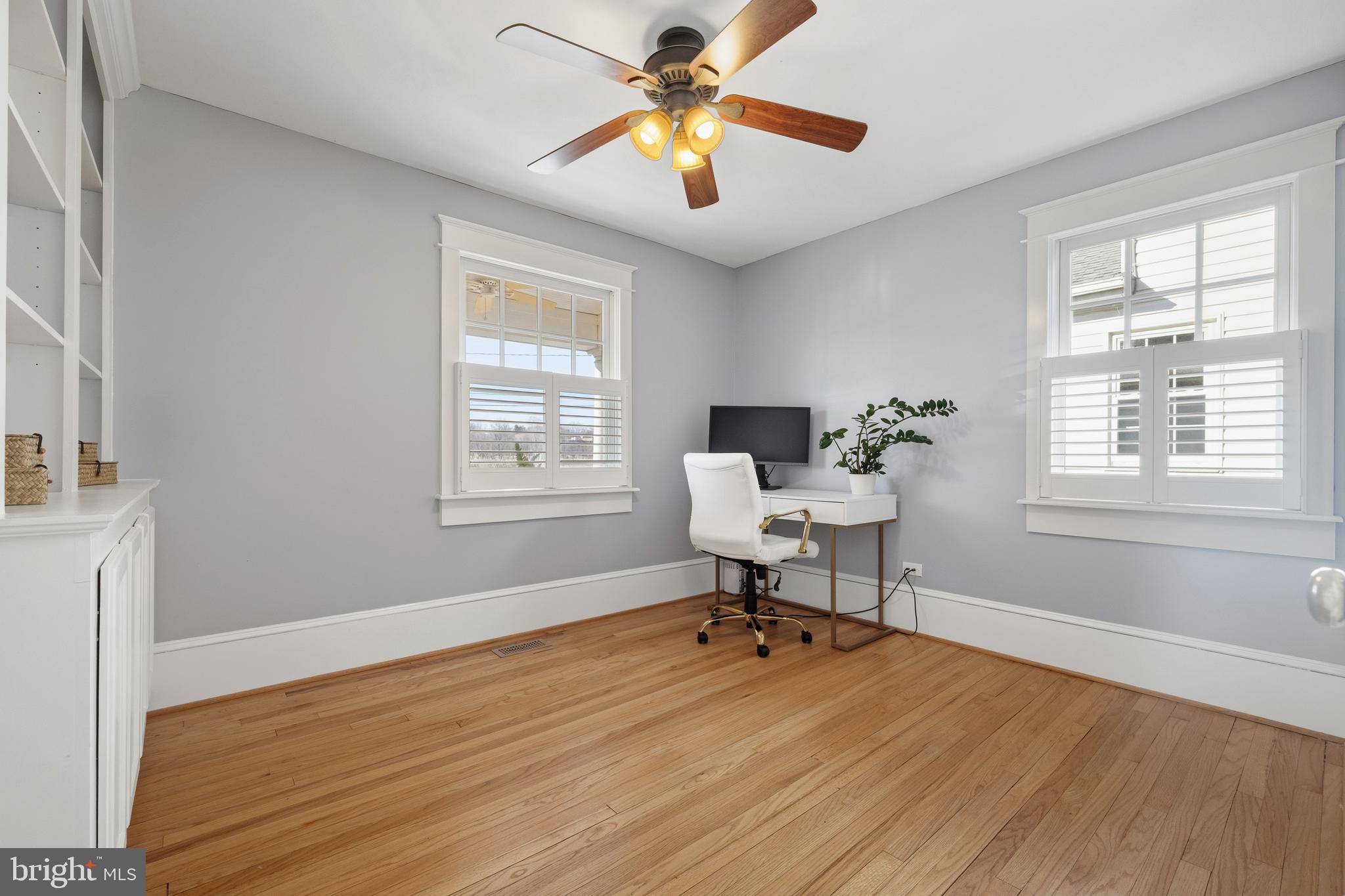 304 Locust Avenue Annapolis, MD 21401 - Photo 11 of 58 a workspace with wooden floor a chandelier fan and windows