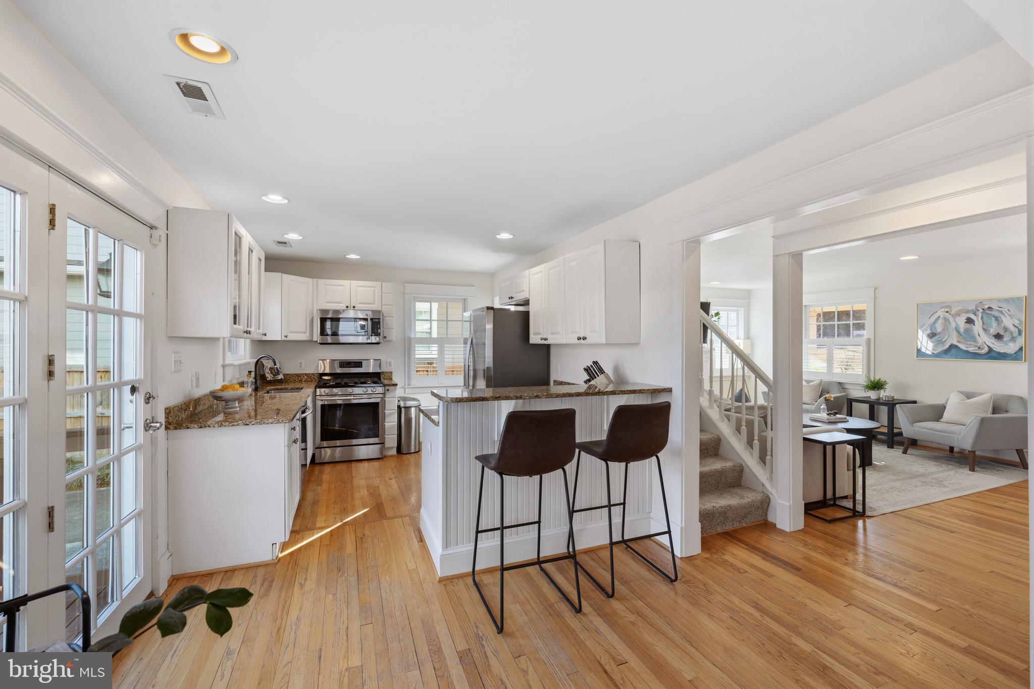 304 Locust Avenue Annapolis, MD 21401 - Photo 8 of 58 a kitchen with stainless steel appliances kitchen island wooden floors and view living room