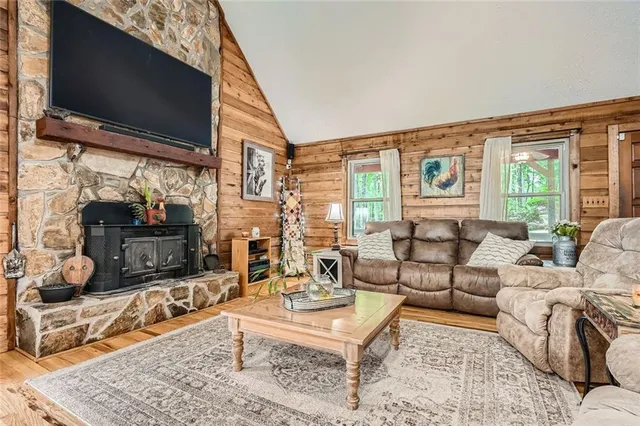 a living room with stainless steel appliances kitchen island granite countertop furniture a rug kitchen view and a fireplace