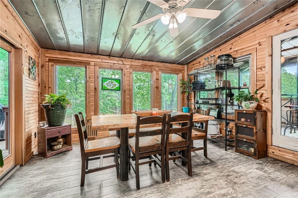 5419 Tyree Road Winston, GA 30187 - Photo 23 of 77 a dining room with furniture floor to ceiling windows and potted plants
