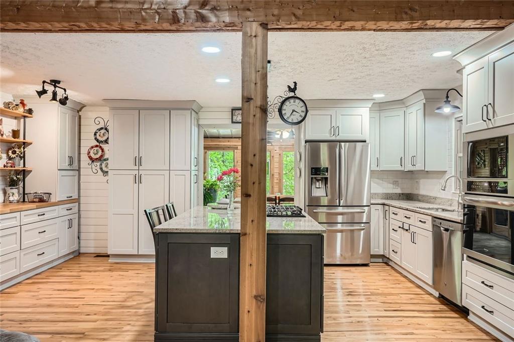 5419 Tyree Road Winston, GA 30187 - Photo 30 of 77 a kitchen with stainless steel appliances kitchen island granite countertop a stove a sink and a refrigerator