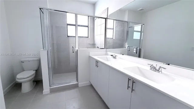 a bathroom with a double vanity sink toilet and a mirror