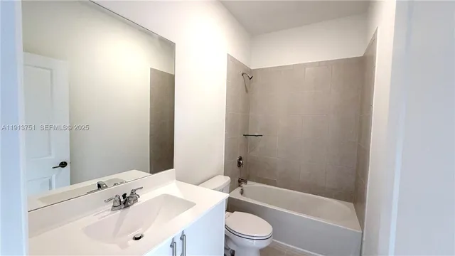 a bathroom with a bathtub shower sink vanity and toilet