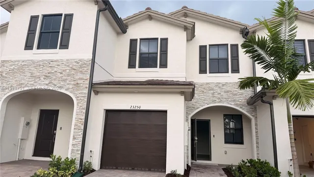 a front view of a house with plants