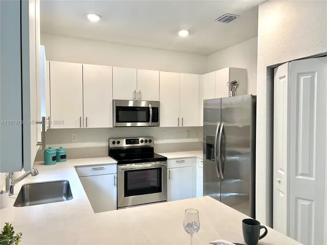 a kitchen with stainless steel appliances a refrigerator stove microwave and sink