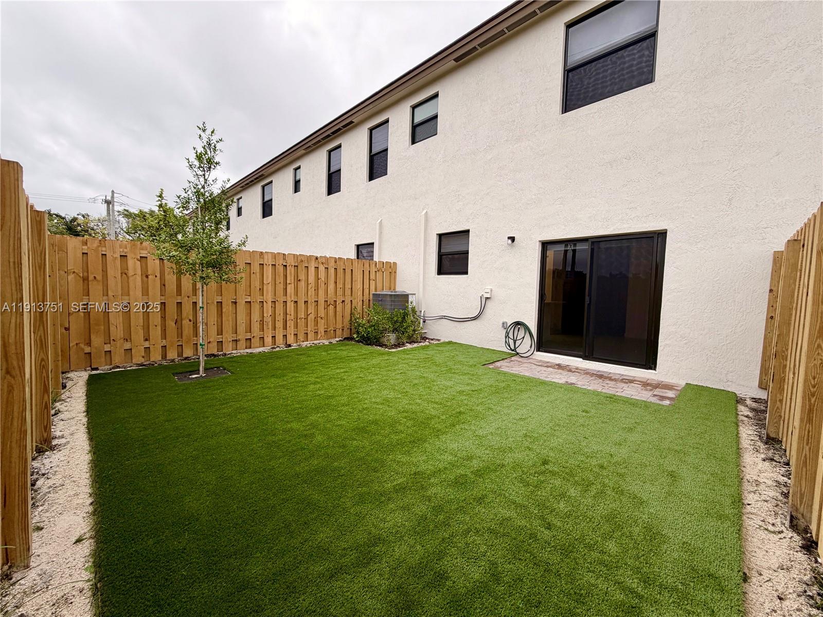 23250 Southwest 133rd Court Homestead, FL 33032 - Photo 30 of 31 a view of a white house with a yard and a garden