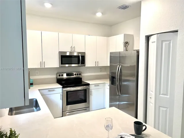 a kitchen with stainless steel appliances granite countertop a stove a refrigerator and a microwave