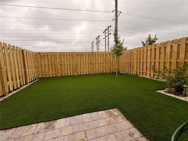 a view of a backyard with wooden fence