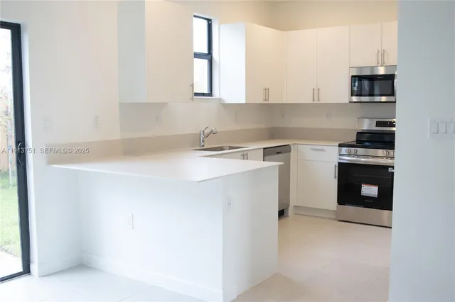 a kitchen with stainless steel appliances a sink stove and cabinets