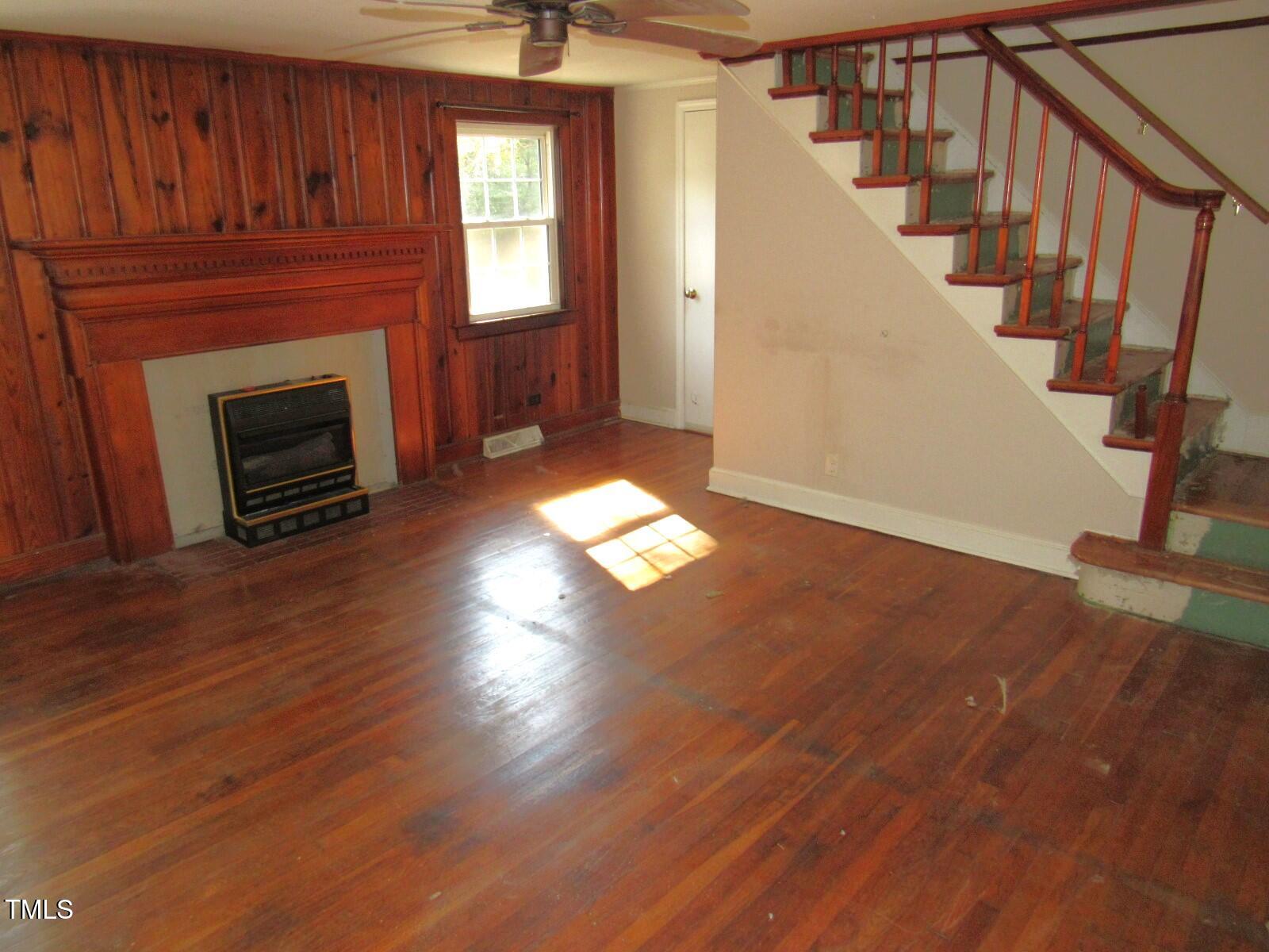 3518 Cheek Road Durham, NC 27704 - Photo 3 of 38 a living room with wooden floors and a fireplace