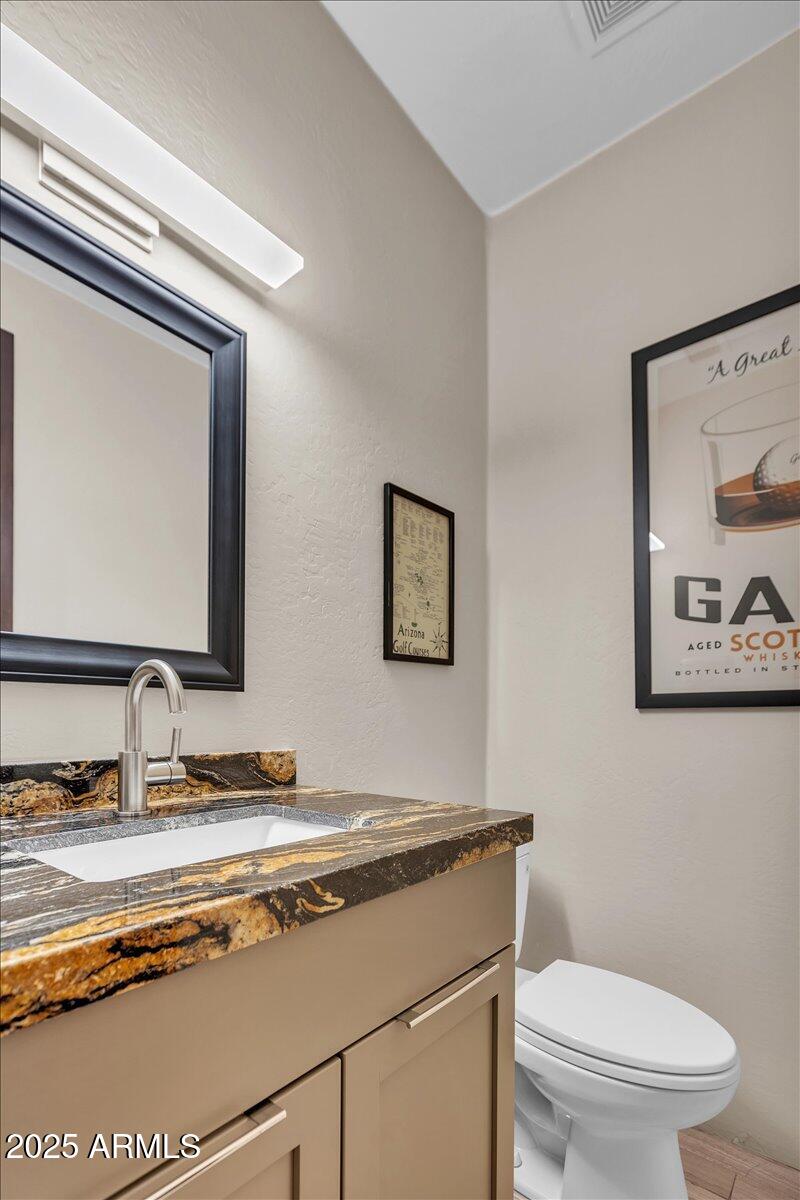 10040 East Happy Valley Road, Unit 300 Scottsdale, AZ 85255 - Photo 13 of 92 a bathroom with a toilet a sink and mirror