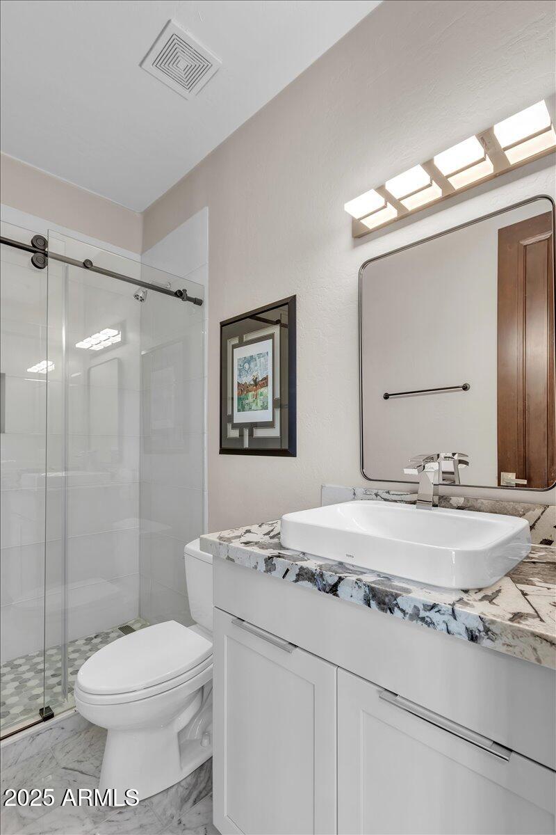 10040 East Happy Valley Road, Unit 300 Scottsdale, AZ 85255 - Photo 38 of 92 a bathroom with a granite countertop sink toilet and shower