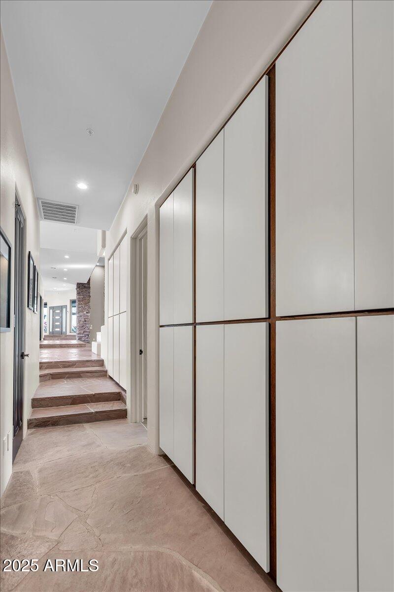 10040 East Happy Valley Road, Unit 300 Scottsdale, AZ 85255 - Photo 39 of 92 a view of a hallway with wooden cabinets and staircase
