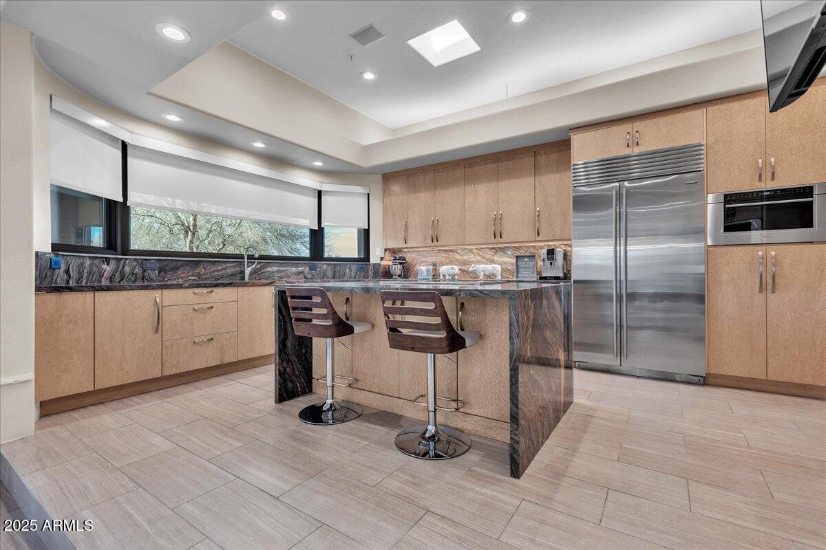 10040 East Happy Valley Road, Unit 300 Scottsdale, AZ 85255 - Photo 8 of 92 a kitchen with stainless steel appliances kitchen island granite countertop a refrigerator and a stove top oven