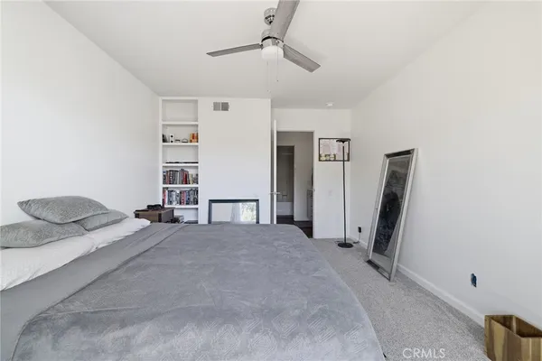 a bedroom with a bed and a flat tv screen on the dresser