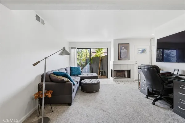 a living room with furniture a fireplace and a flat screen tv