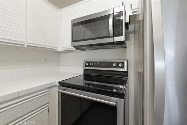 a kitchen with wooden cabinets and stainless steel appliances