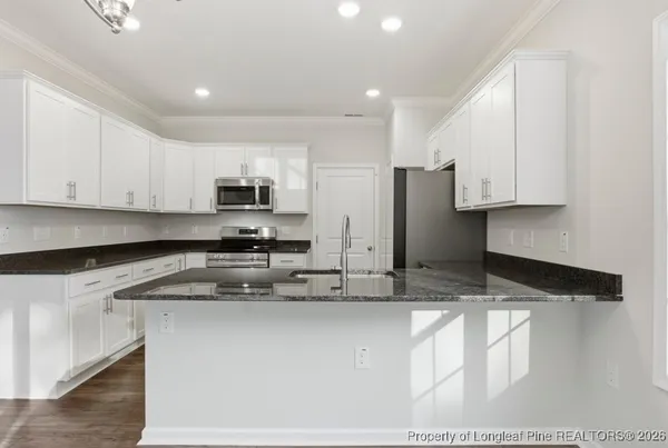 a kitchen with stainless steel appliances granite countertop a sink a stove and a refrigerator