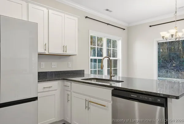 a kitchen with granite countertop white cabinets and black appliances