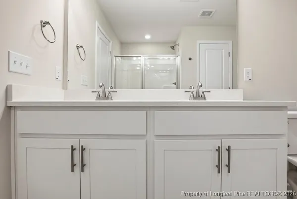 a bathroom with a double vanity sink and a mirror
