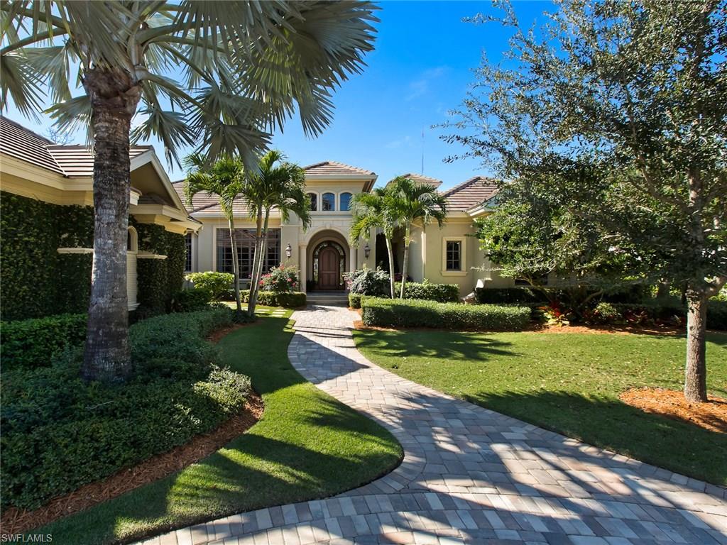 a front view of a house with garden and trees