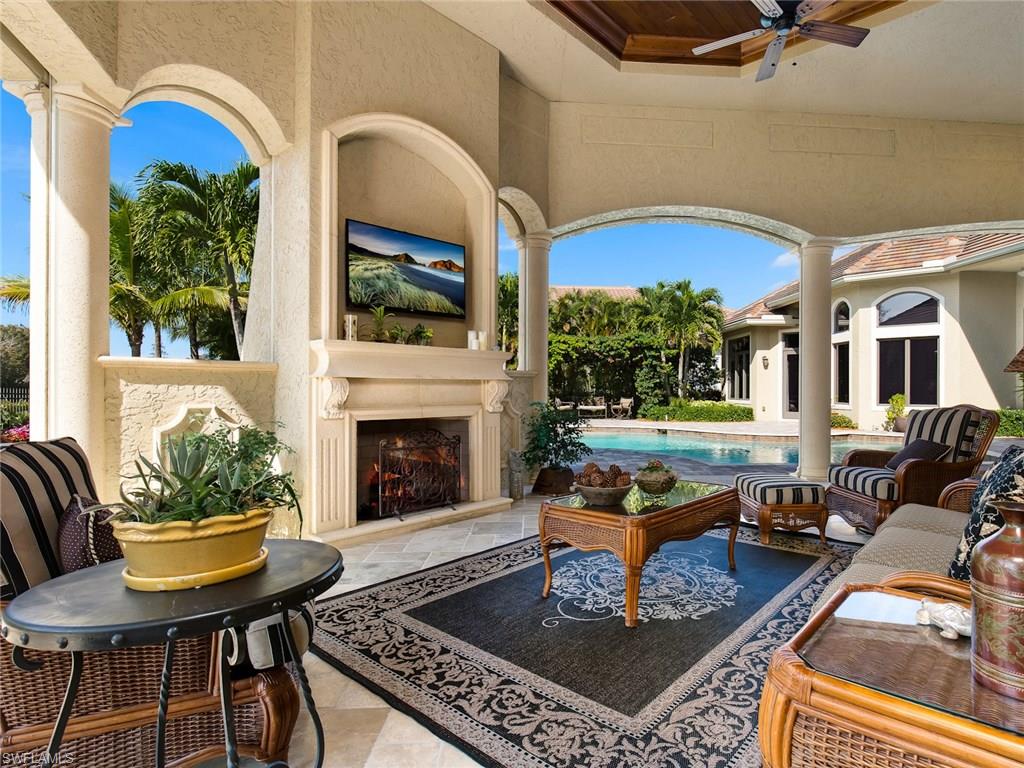 29170 Marcello Way Naples, FL 34110 - Photo 15 of 21 a living room with furniture a fireplace and windows