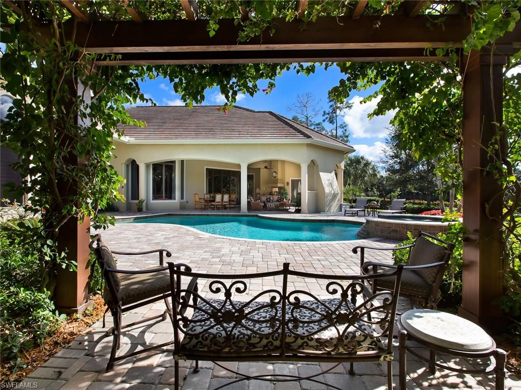 29170 Marcello Way Naples, FL 34110 - Photo 18 of 21 a view of a patio with table and chairs with wooden floor and fence