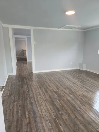 a view of a room with wooden floor and a sink