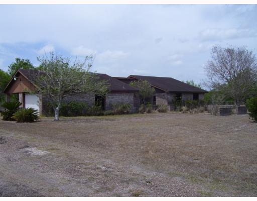 a view of house with a yard and a large tree