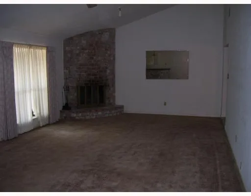 a view of a livingroom with an empty space and a fireplace