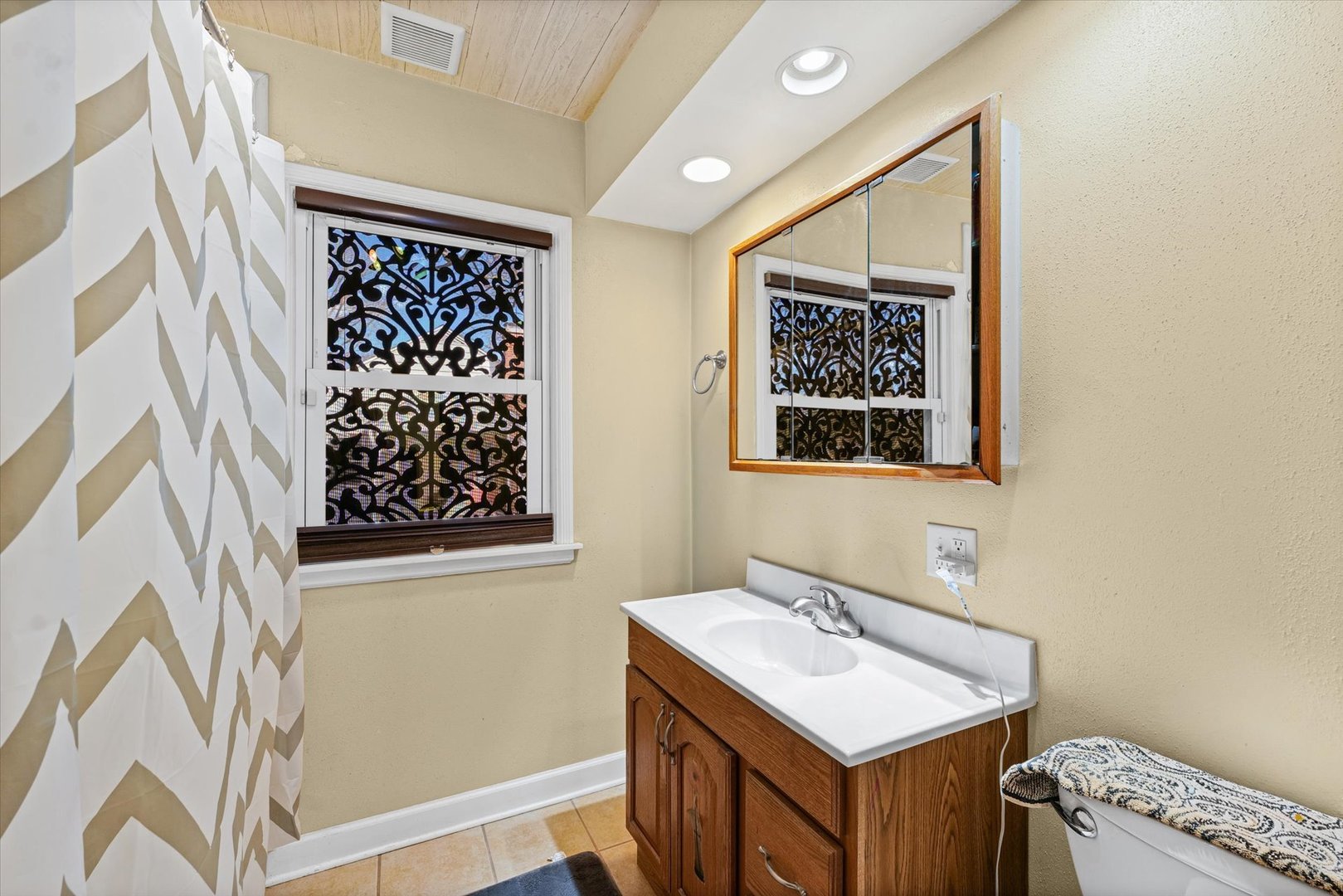 1608 West Springfield Avenue Champaign, IL 61821 - Photo 19 of 36 a bathroom with a sink a mirror and a painting on the wall