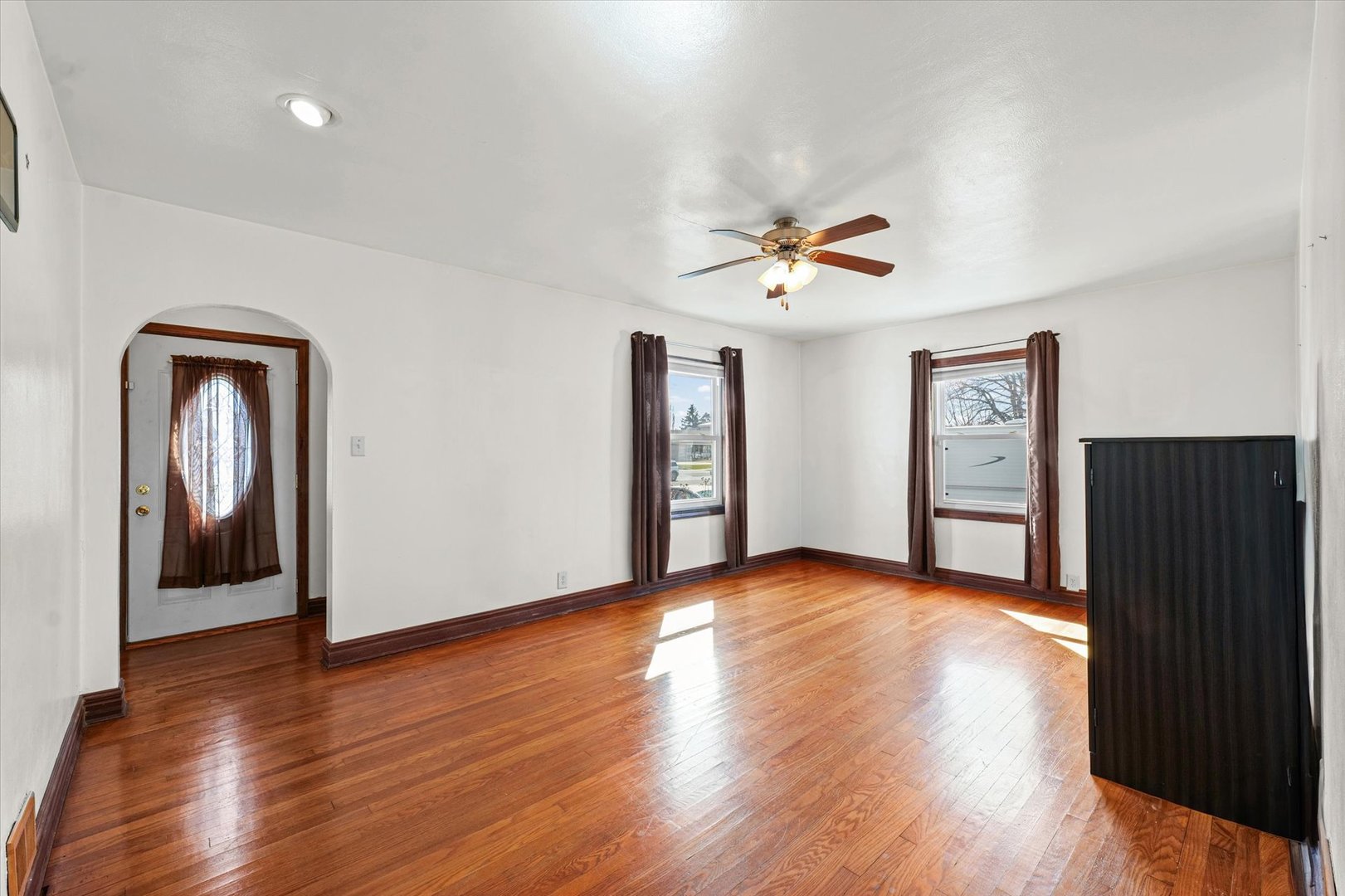 1608 West Springfield Avenue Champaign, IL 61821 - Photo 8 of 36 a view of a livingroom with wooden floor and a ceiling fan