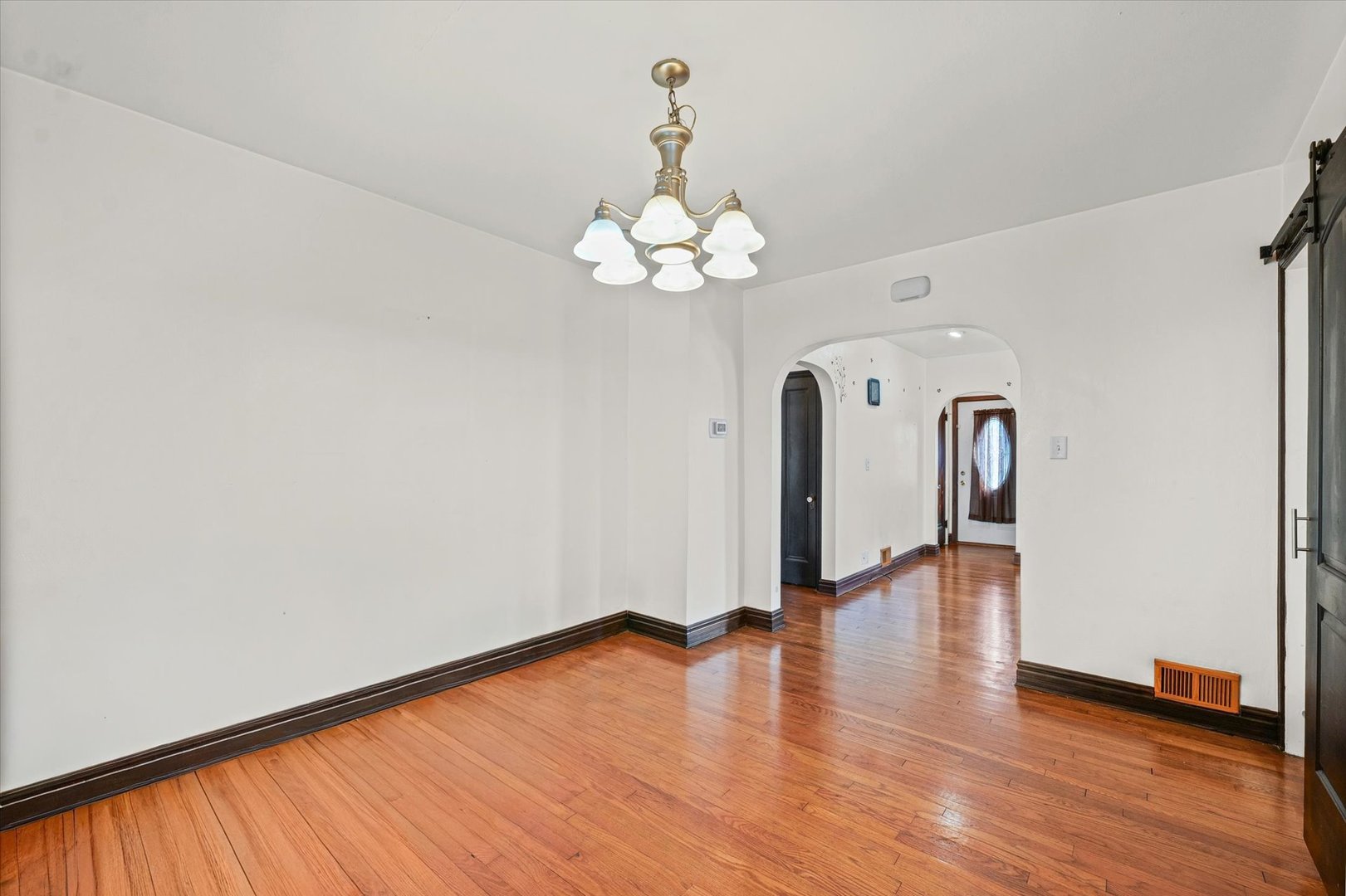 1608 West Springfield Avenue Champaign, IL 61821 - Photo 10 of 36 a view of a room with wooden floor chandelier and a window