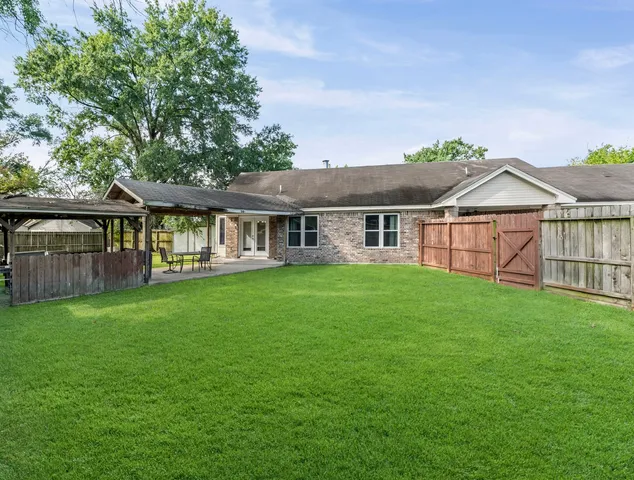 a view of a house with a yard and sitting area