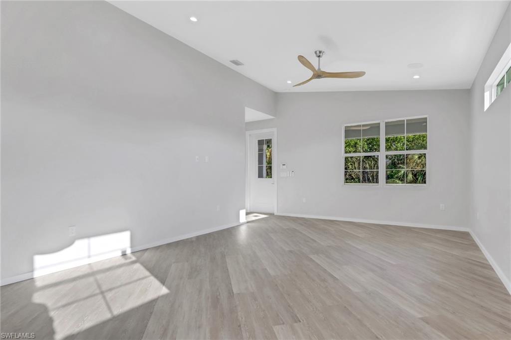 3500 Croton Road, Unit 101 Naples, FL 34104 - Photo 21 of 27 an empty room with wooden floor and windows