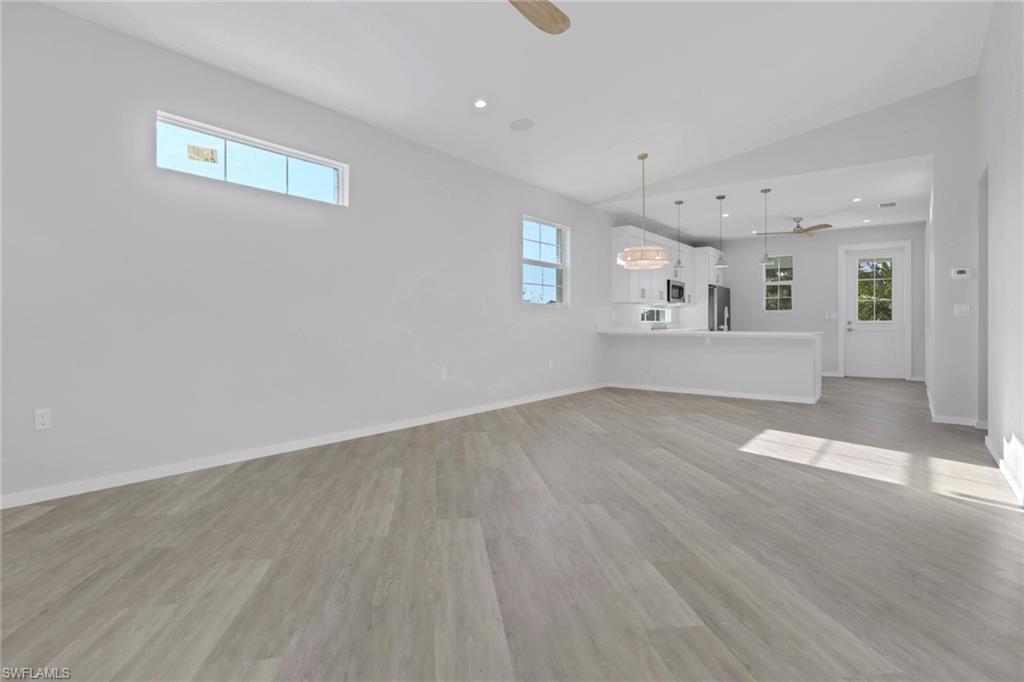 3500 Croton Road, Unit 101 Naples, FL 34104 - Photo 22 of 27 an empty room with wooden floor and windows