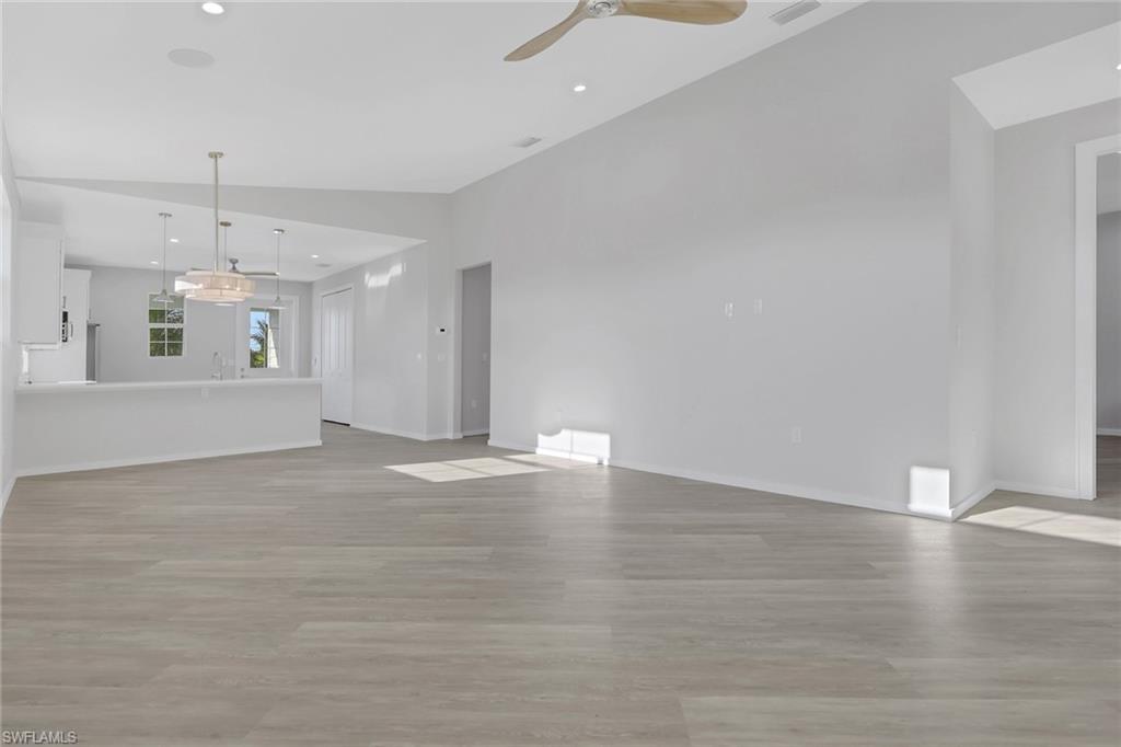 3500 Croton Road, Unit 101 Naples, FL 34104 - Photo 4 of 27 a view of an empty room with wooden floor and kitchen