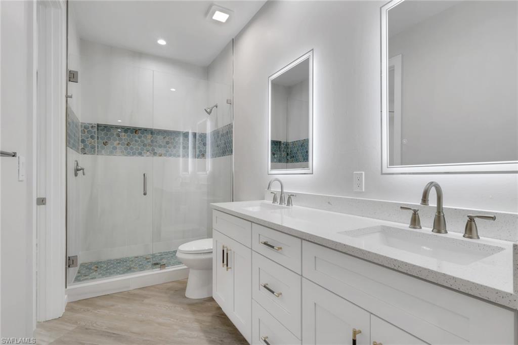 3500 Croton Road, Unit 101 Naples, FL 34104 - Photo 9 of 27 a bathroom with a double vanity sink toilet and shower