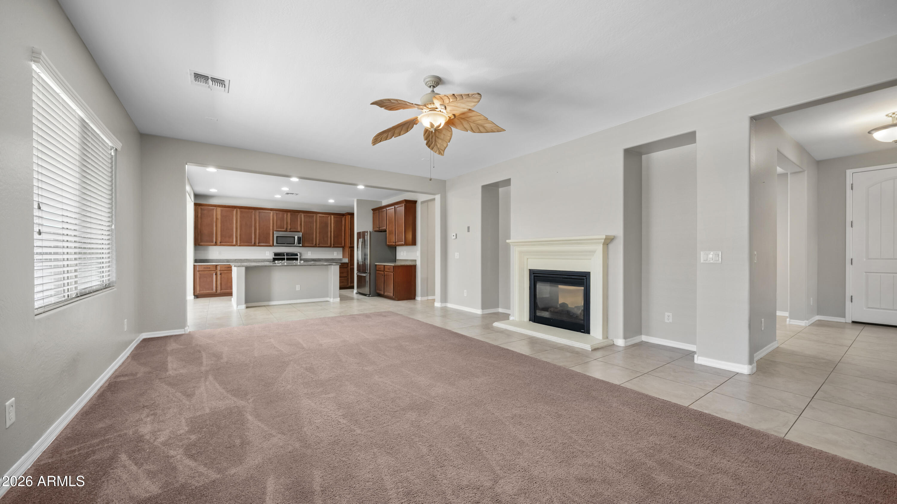 16159 West Granada Road Goodyear, AZ 85395 - Photo 10 of 41 a view of a kitchen with a cabinet a fireplace a ceiling fan and windows